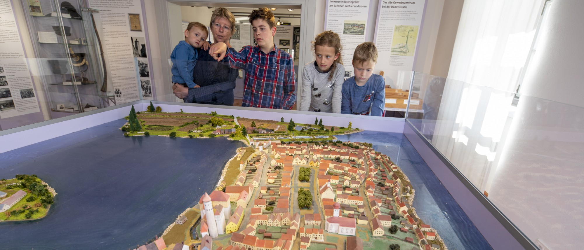 Frau und vier Kinder blicken auf ein historisches Modell von Tirschenreuth